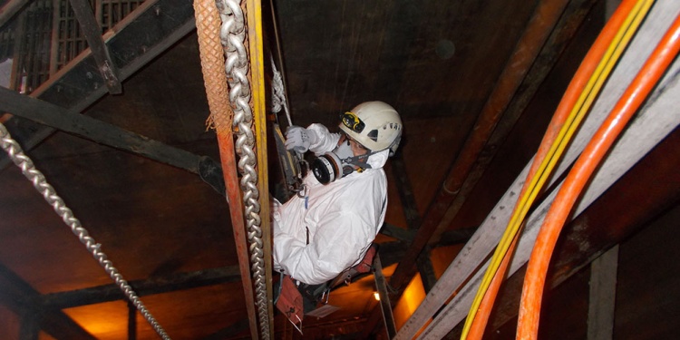 Worker wearing a respirator in a confined space.